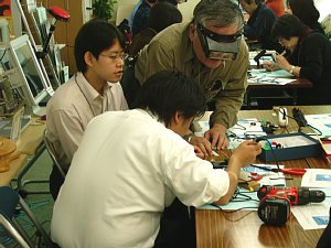 小野師匠がハンダ付けのアドバイスをしているの写真